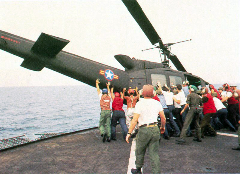 A South Vietnamese UH-1 is pushed overboard on the USS Midway in 1975