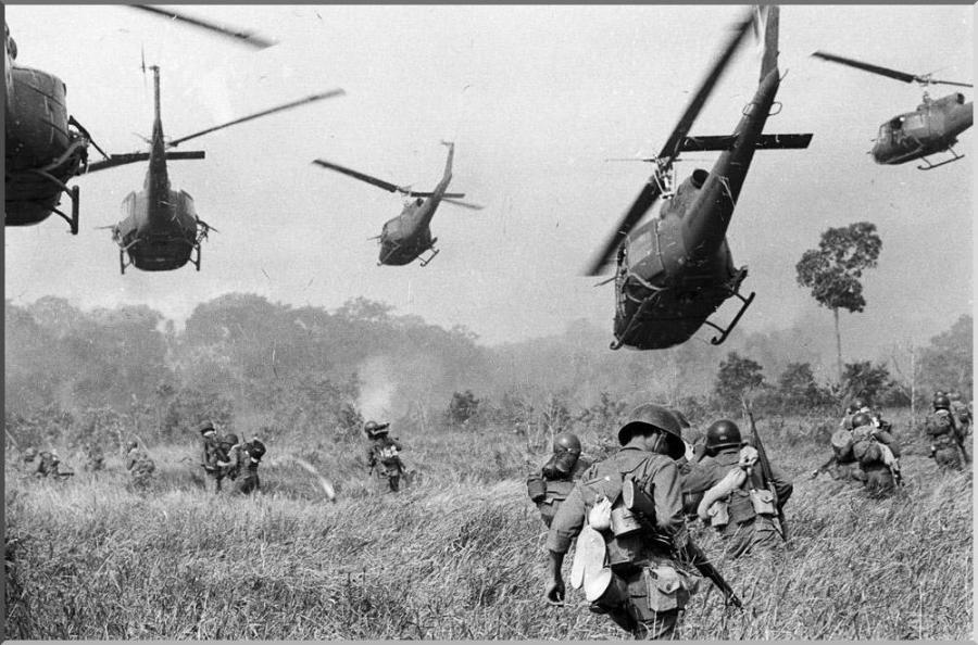 Hovering U.S. Army helicopters pour machine gun fire into a tree line to cover the advance of South Vietnamese ground troops in an attack on a Viet Cong camp 18 miles north of Tay Ninh northwest of Saigon near the Cambodian border, in Vietnam on March 1965 